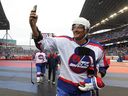 Winnipeg Jets forward Teemu Selanne whips out his phone as he leaves the ice after the second period of the Heritage Classic alumni game against the Edmonton Oilers  in Winnipeg on Sat., Oct. 22, 2016. Selanne is joining the Jets Hall of Fame. Kevin King/Winnipeg Sun/Postmedia Network