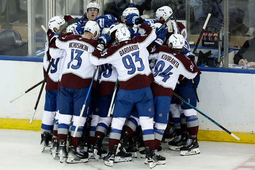 Colorado Avalanche center Nathan MacKinnon (29) is surrounded by teammates after scoring the game-winning goal in overtime of an NHL hockey game against the New York Rangers, Saturday, Dec. 6, 2025, in New York. (AP Photo/Adam Hunger)