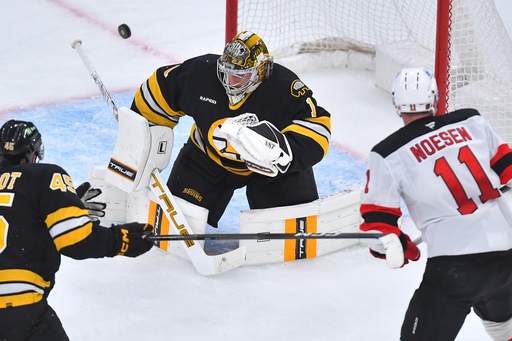 Boston Bruins goaltender Jeremy Swayman (1) deflects the puck as New Jersey Devils right wing Stefan Noesen (11) is unable to score as defenseman Jonathan Aspirot (45) looks on in the second period of an NHL hockey game, Saturday, Dec. 6, 2025, in Boston. (AP Photo/Steven Senne)