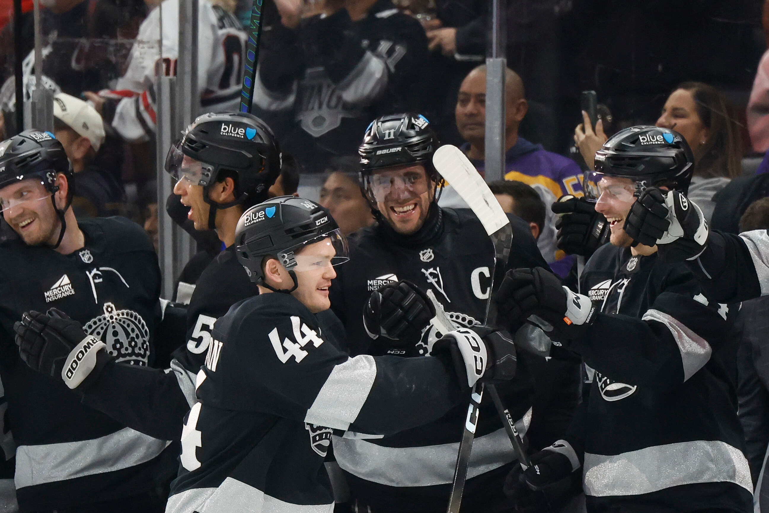 Kings defenseman Mikey Anderson (44) is greeted by teammates after...