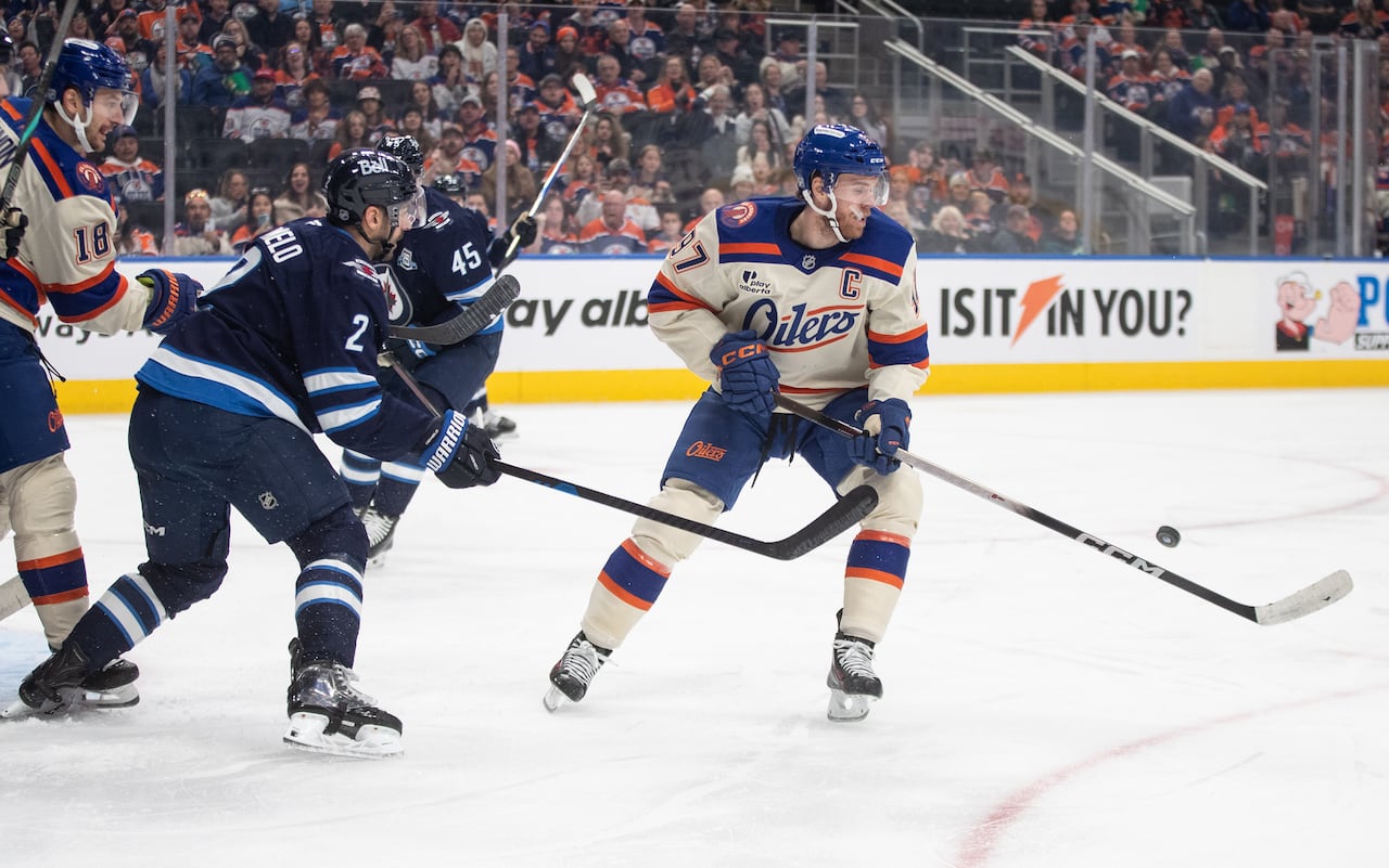 Two hockey players scramble to collect a loose puck.