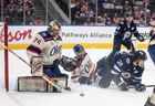 Winnipeg Jets' Morgan Barron (36) and  Edmonton Oilers' Evan Bouchard (2) battle in front as goalie Stuart Skinner (74) makes the save during third period NHL action, in Edmonton on Saturday, December 6, 2025.   The Jets surrendered four first-period goals in a 6-2 loss. 