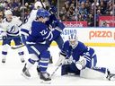 Toronto Maple Leafs goaltender Dennis Hildeby (35) makes a save in front of Tampa Bay Lightning's Jake Guentzel (59) and Leafs defenceman Jake McCabe (22) during period NHL hockey action in Toronto, Monday, Dec. 8, 2025. 