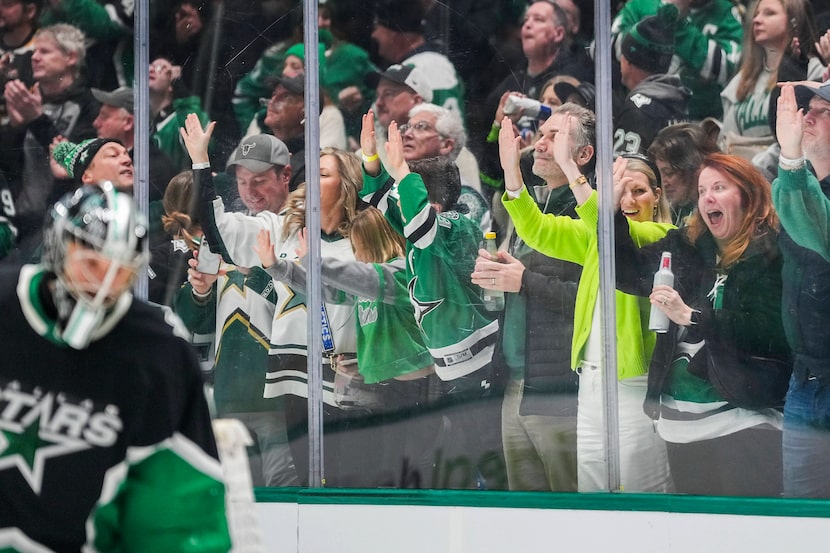 Dallas Stars fans celebrate a goal by center Wyatt Johnston behind goaltender Casey Desmith...