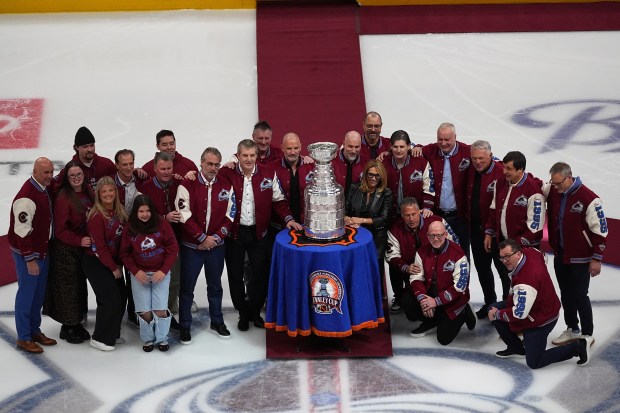Members from the 1996 Stanley Cup Championship team of the Colorado Avalanche gather for a group shot during a ceremony to mark the 30th anniversary of winning the Cup before an NHL hockey game against the Florida Panthers, Thursday, Dec. 11, 2025, in Denver. (AP Photo/David Zalubowski)