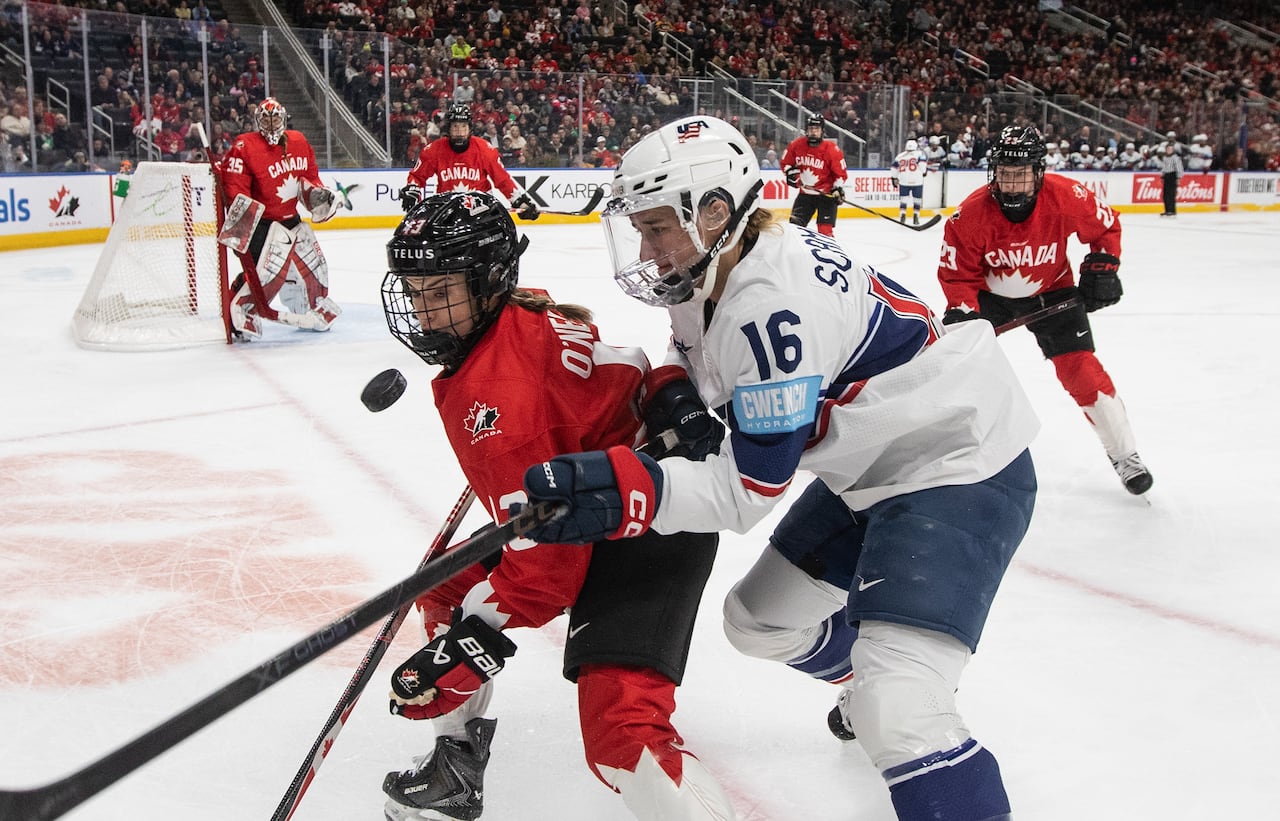 Hockey players jostle for the puck.