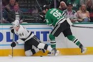 Los Angeles Kings defenseman Mikey Anderson (44) falls to the ice while competing for the...