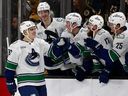 Liam Ohgren of the Vancouver Canucks smiles as he is congratulated at the bench after scoring the only goal in a seven round shootout against the Boston Bruins  TD Garden on Dec. 20, 2025 in Boston, Massachusetts.
