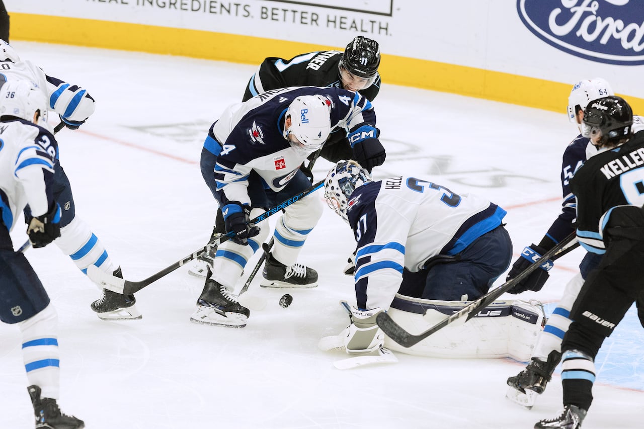A scramble in front of the net for the puck.