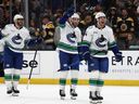 Kiefer Sherwood, Max Sasson and Evander Kane head for their goaltender after the Vancouver Canucks' 5-4 win over the Boston Bruins in a shootout at TD Garden on Dec. 20, 2025.