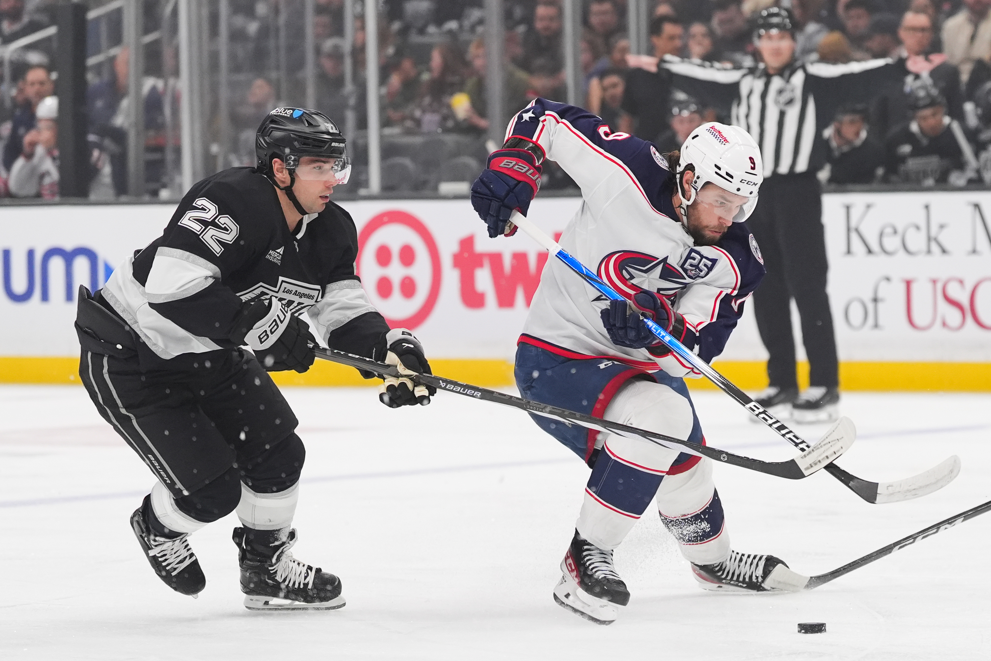 Columbus Blue Jackets defenseman Ivan Provorov, right, moves the puck...