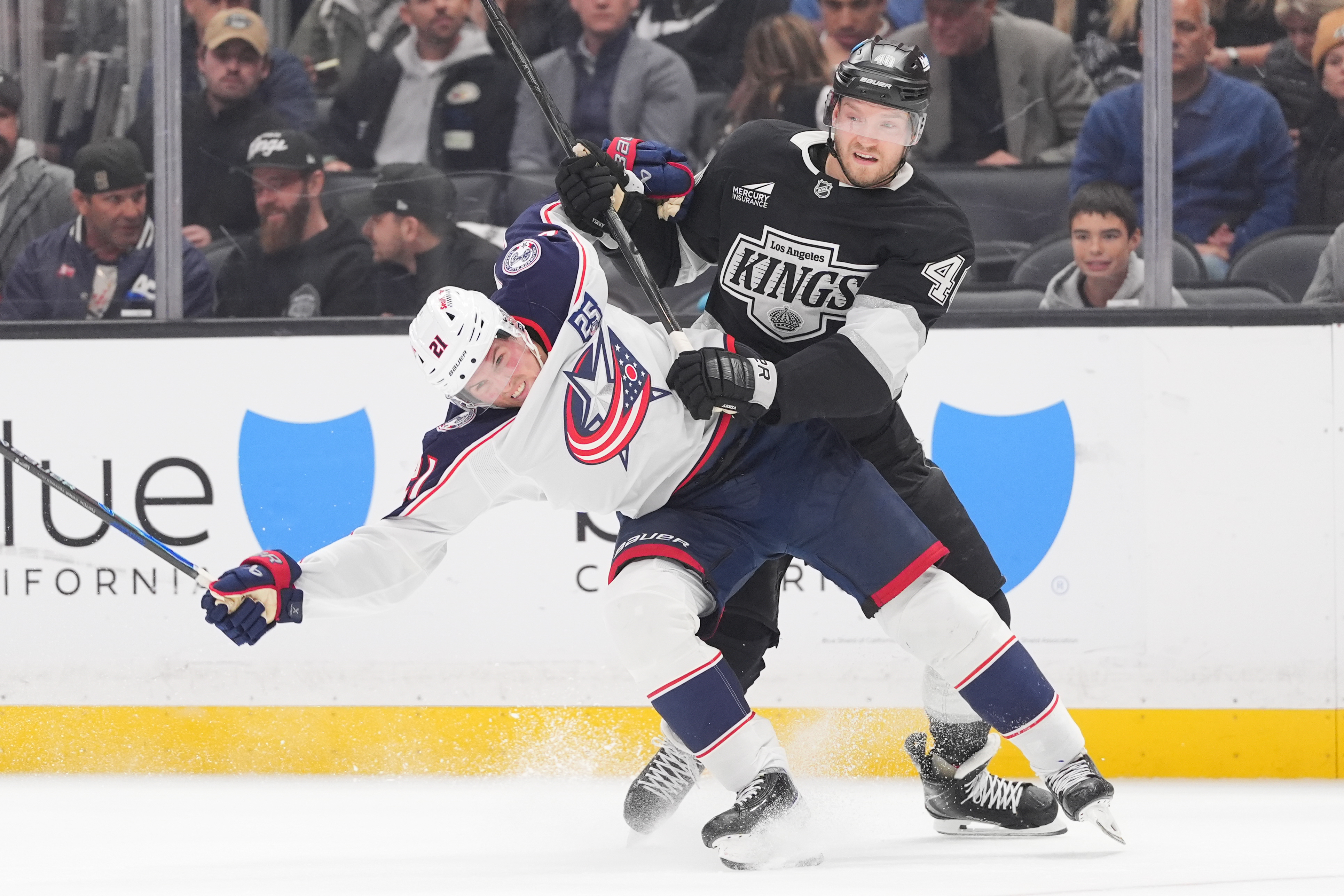 Columbus Blue Jackets center Isac Lundestrom, left, gets tangled up...