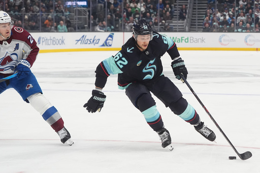 Seattle Kraken defenseman Brandon Montour (62) moves the puck against Colorado Avalanche center Nathan MacKinnon (29) during the first period of an NHL hockey game Tuesday, Dec. 16, 2025, in Seattle. (AP Photo/Lindsey Wasson)