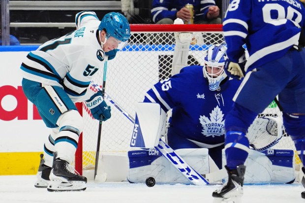 Toronto Maple Leafs goaltender Dennis Hildeby (35) makes a save as San Jose Sharks' Collin Graf (51) looks for the rebound during second period NHL hockey action in Toronto on Thursday, Dec. 11, 2025. (Frank Gunn/The Canadian Press via AP)