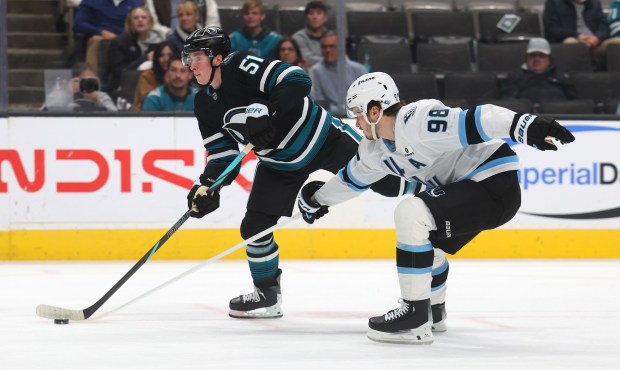 San Jose Sharks forward Collin Graf (51) shoots the puck while being defended by Utah Mammoth's Mikhail Sergachev (98) during the first period of their game on Monday, Dec.1, 2025, in San Jose, Calif. (Aric Crabb/Bay Area News Group)
