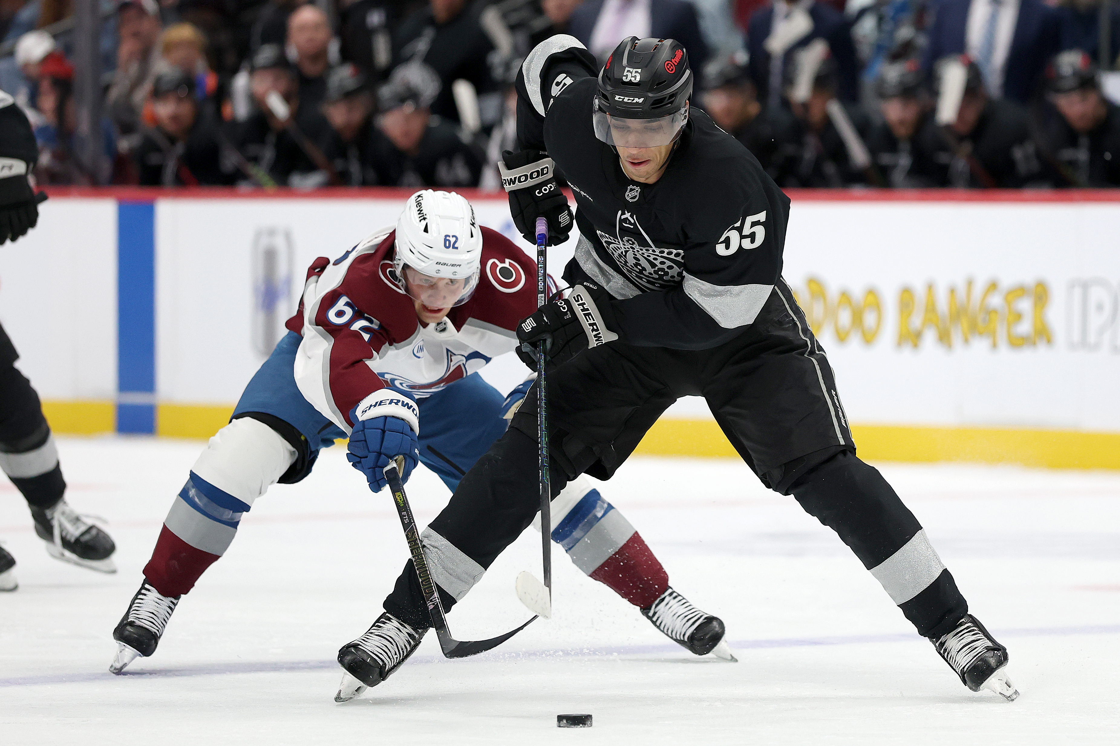 The Kings’ Quinton Byfield, right, advances the puck in front...