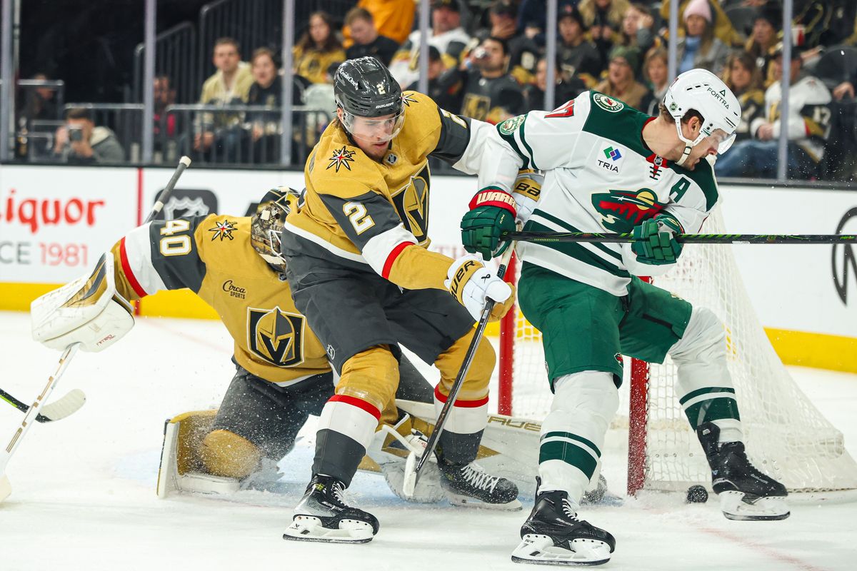 Vegas Golden Knights D Zach Whitecloud (2) pushes Minnesota Wild F Marcus Foligno (17) off the puck during an NHL game on Monday December 29, 2025, in Las Vegas, Nevada. 