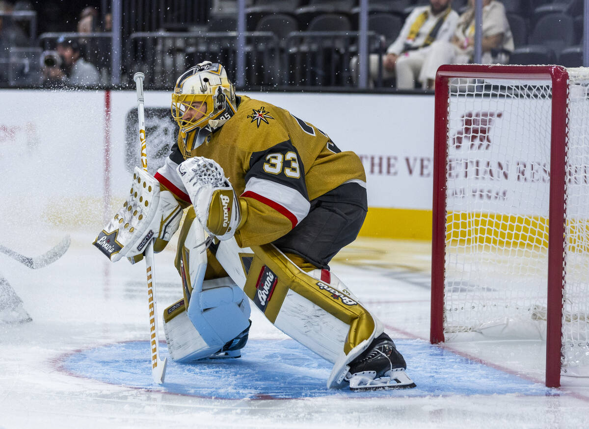 Golden Knights goaltender Adin Hill (33) is showered in ice as he defends the net against the U ...