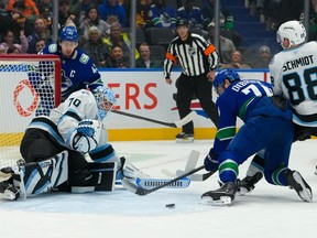 Karel Vejmelka #70 of the Utah Mammoth makes a save on Jake DeBrusk #74 during the first period