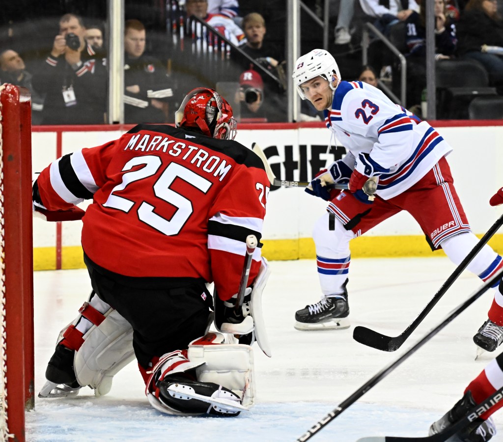 Devils goaltender Jacob Markstrom (25) stops a shot by Rangers defenseman Adam Fox (23) in the third period of the Rangers - Devils hockey game in Newark, NJ.