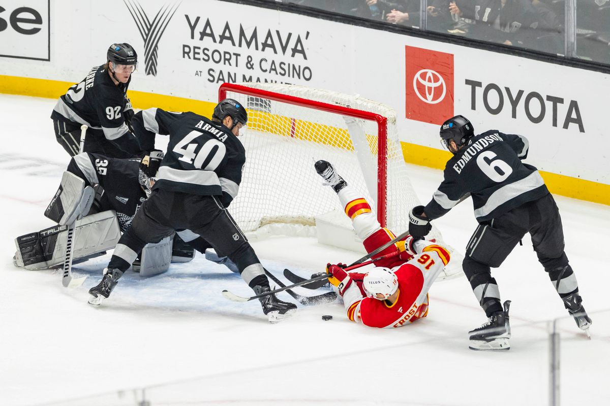 Center Morgan Frost #16 of the Calgary Flames tries to get the loose puck in the net while surrounded by Los Angeles Kings players during an NHL hockey game, Saturday December 13, 2025 in Los Angeles, Calif. Center Morgan Frost #16 of the Calgary Flames tries to get the loose puck in the net while surrounded by Los Angeles Kings players during an NHL hockey game, Saturday December 13, 2025 in Los Angeles, Calif.