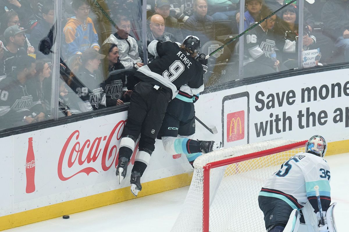 Los Angeles Kings right wing Adrian Kempe (9) fights for the puck against the Kraken at the crypto.com Arena on December 23,2025 in Los Angeles, California.