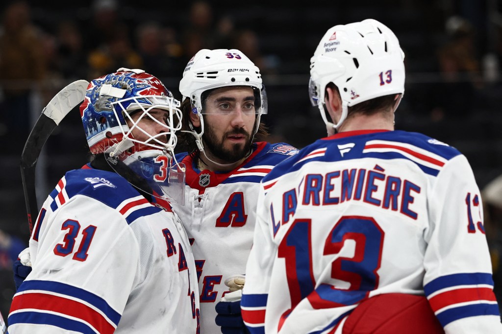 New York Rangers goaltender Igor Shesterkin (31) is congratulated by left wing Alexis Lafrenière (13) and center Mika Zibanejad (93).