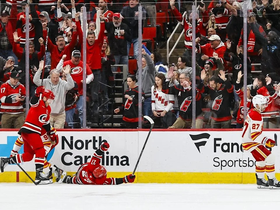  Hurricanes forward Nikolaj Ehlers celebrates his overtime goal with Taylor Hall (left) as Flames forward Matt Coronato skates away.