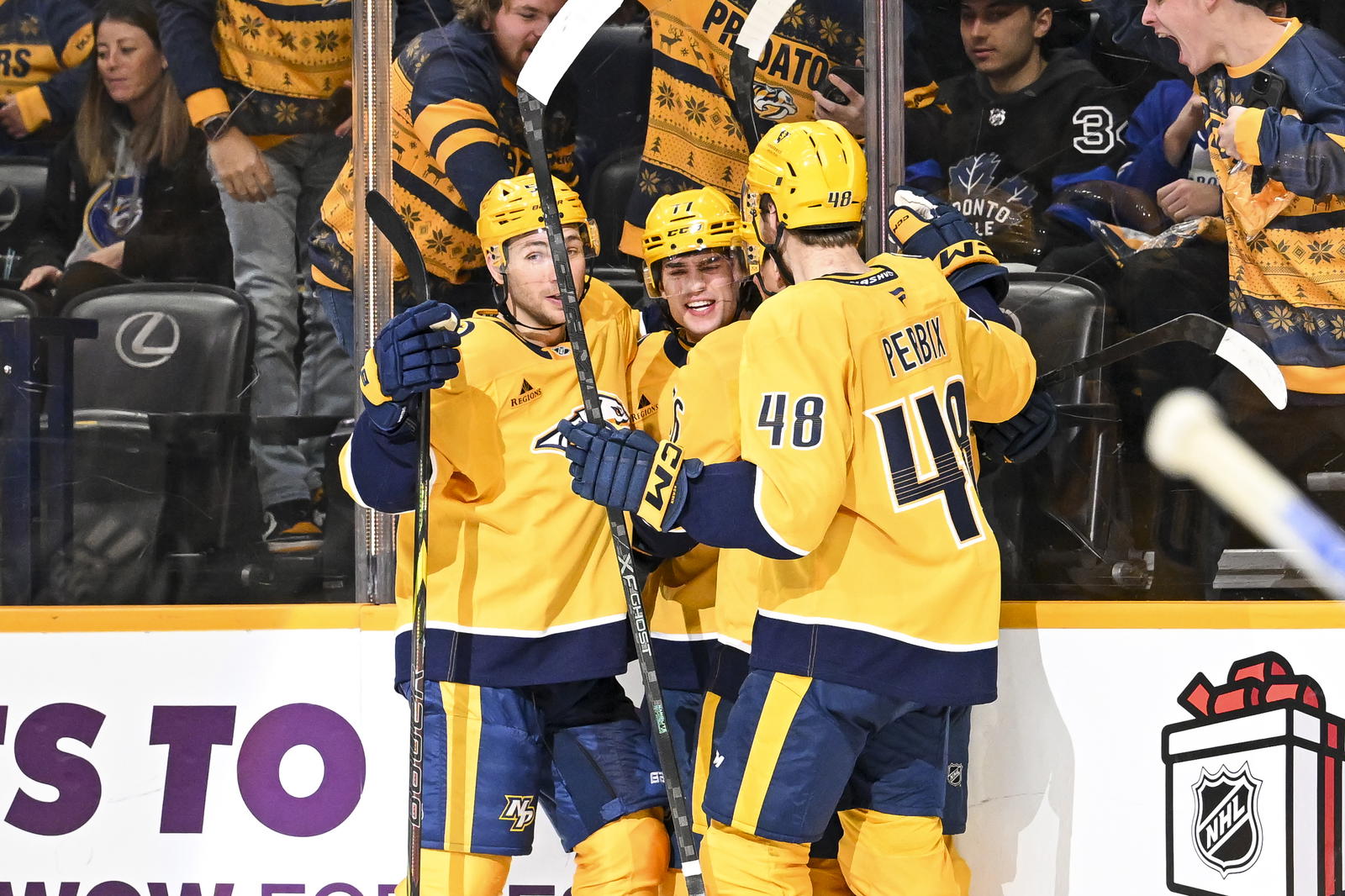 Dec 20, 2025; Nashville, Tennessee, USA; Nashville Predators right wing Luke Evangelista (77) celebrates with his teammates after scoring a goal against the Toronto Maple Leafs during the third period at Bridgestone Arena. Mandatory Credit: Steve Roberts-Imagn Images