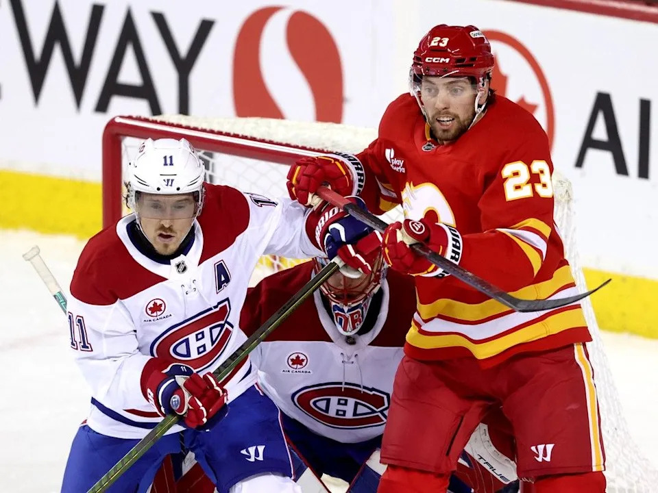  Calgary Flames forward Justin Kirkland battles Montreal Canadiens forward Brendan Gallagher at Scotiabank Saddledome on Oct. 22, 2025.