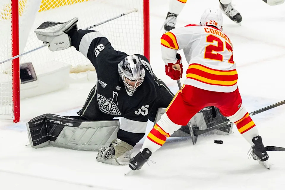 Goaltender Darcy Kuemper #35 of the Los Angeles Kings makes a save against right wing Matt Coronato #27 of the Calgary Flames during an NHL hockey game, Saturday December 13, 2025 in Los Angeles, Calif.