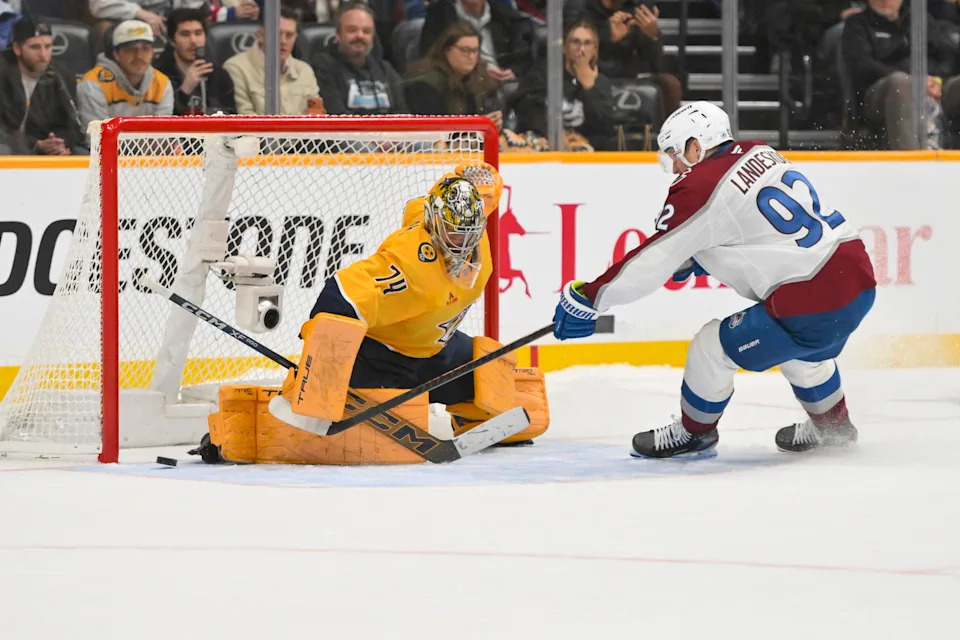 Dec 9, 2025; Nashville, Tennessee, USA; Nashville Predators goaltender Juuse Saros (74) blocks the shot of Colorado Avalanche left wing Gabriel Landeskog (92) during the shootout at Bridgestone Arena. Mandatory Credit: Steve Roberts-Imagn Images