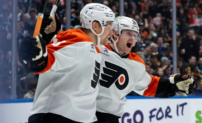 Philadelphia Flyers' Carl Grundstrom (91) celebrates his goal against the Vancouver Canucks with Rodrigo Abols (18) during the second period of an NHL hockey game in Vancouver, B.C., Tuesday, Dec. 30, 2025. (Ethan Cairns/The Canadian Press via AP)
