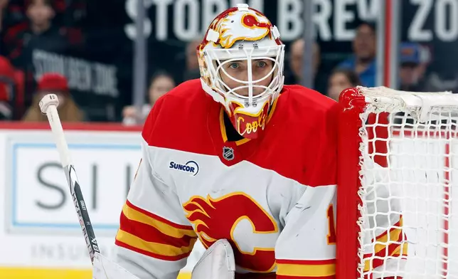 Calgary Flames goaltender Devin Cooley watches the puck against the Carolina Hurricanes during the second period of an NHL hockey game in Raleigh, N.C., Sunday, Nov. 30, 2025. (AP Photo/Karl DeBlaker)