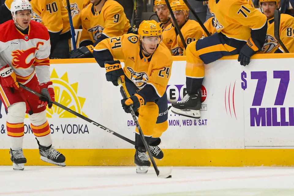 Dec 2, 2025; Nashville, Tennessee, USA; Nashville Predators defenseman Spencer Stastney (24) skates with the puck against the Calgary Flames during the first period at Bridgestone Arena. Mandatory Credit: Steve Roberts-Imagn Images