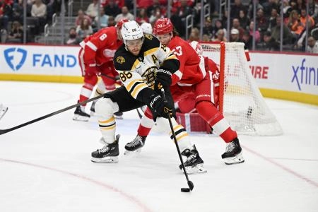 Mar 29, 2025; Detroit, Michigan, USA; Boston Bruins right wing David Pastrnak (88) skates around the front of the Detroit Red Wings goal as Red Wings defenseman Moritz Seider (53) defends in the first period at Little Caesars Arena.