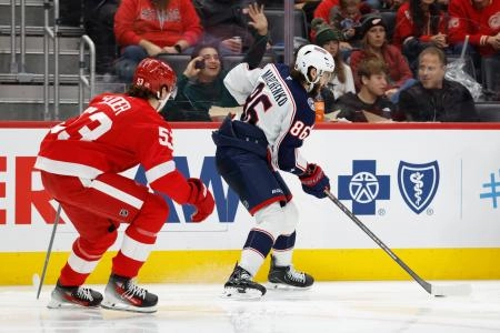 Nov 22, 2025; Detroit, Michigan, USA; Columbus Blue Jackets right wing Kirill Marchenko (86) skates with the puck defended by Detroit Red Wings defenseman Moritz Seider (53) in the third period at Little Caesars Arena. Mandatory Credit: Rick Osentoski-Imagn Images