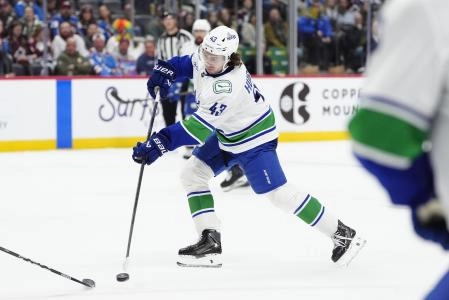 Dec 2, 2025; Denver, Colorado, USA; Vancouver Canucks defenseman Quinn Hughes (43) takes a shot on goal in the third period against the Colorado Avalanche at Ball Arena. Mandatory Credit: Ron Chenoy-Imagn Images