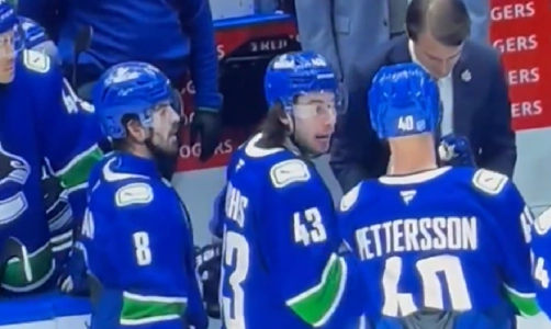 Vancouver Canucks captain Quinn Hughes talking with Elias Pettersson at the bench in a game. Vancouver Canucks captain Quinn Hughes talking with Elias Pettersson at the bench in a game.