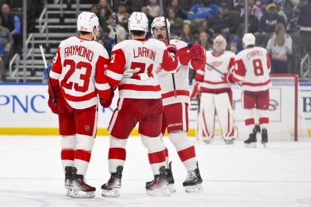 Oct 28, 2025; St. Louis, Missouri, USA; Detroit Red Wings center Dylan Larkin (71) is congratulated by left wing Lucas Raymond (23) and defenseman Travis Hamonic (52) after scoring an empty net goal against the St. Louis Blues during the third period at Enterprise Center.