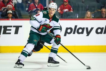 Dec 4, 2025; Calgary, Alberta, CAN; Minnesota Wild defenseman Zeev Buium (8) controls the puck against the Calgary Flames during the first period at Scotiabank Saddledome.