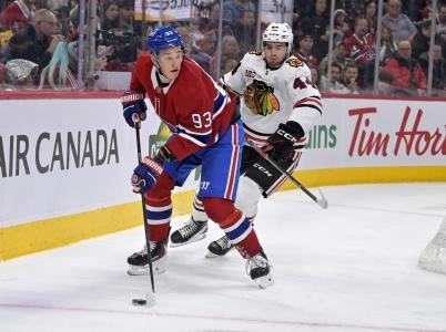 Dec 18, 2025; Montreal, Quebec, CAN; Montreal Canadiens forward Ivan Demidov (93) plays the puck and Chicago Blackhawks defenseman Wyatt Kaiser (44) defends during the first period at the Bell Centre. Mandatory Credit: Eric Bolte-Imagn Images