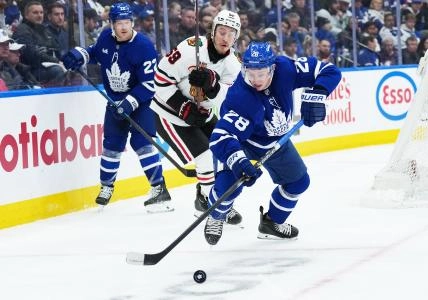 Dec 16, 2025; Toronto, Ontario, CAN; Chicago Blackhawks left wing Tyler Bertuzzi (59) battles for the puck behind the net with Toronto Maple Leafs defenseman Troy Stecher (28) during the second period at Scotiabank Arena. Mandatory Credit: Nick Turchiaro-Imagn Images
