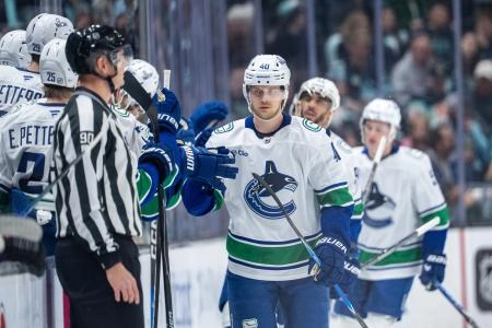 Dec 29, 2025; Seattle, Washington, USA; Vancouver Canucks forward Elias Pettersson (40) is congratulated by teammates on the bench after scoring a goal during the second period against the Seattle Kraken at Climate Pledge Arena.