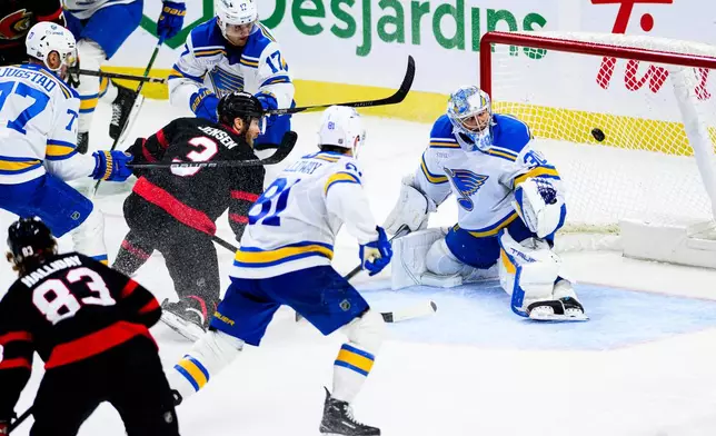 St. Louis Blues goaltender Joel Hofer (30) watches the puck from a shot by Ottawa Senators' Nick Jensen (3) during the third period of an NHL hockey game in Ottawa, Ontario, Saturday, Dec. 6, 2025. (Spencer Colby/The Canadian Press via AP)