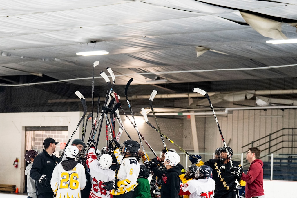 Baltimore Banner hockey players and coaches raise the hockey sticks at the end of practice at Mt. Pleasant Ice Arena, in Baltimore, Saturday, December 20, 2025.