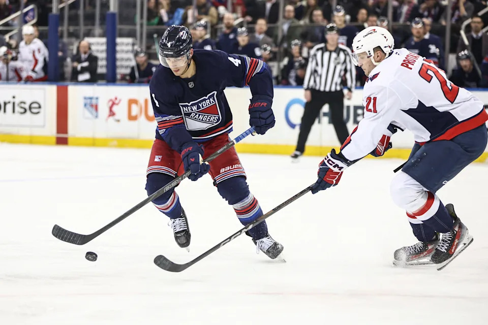 Mar 5, 2025; New York, New York, USA; New York Rangers defenseman Braden Schneider (4) and Washington Capitals center Aliaksei Protas (21) chase after the puck in the second period at Madison Square Garden.