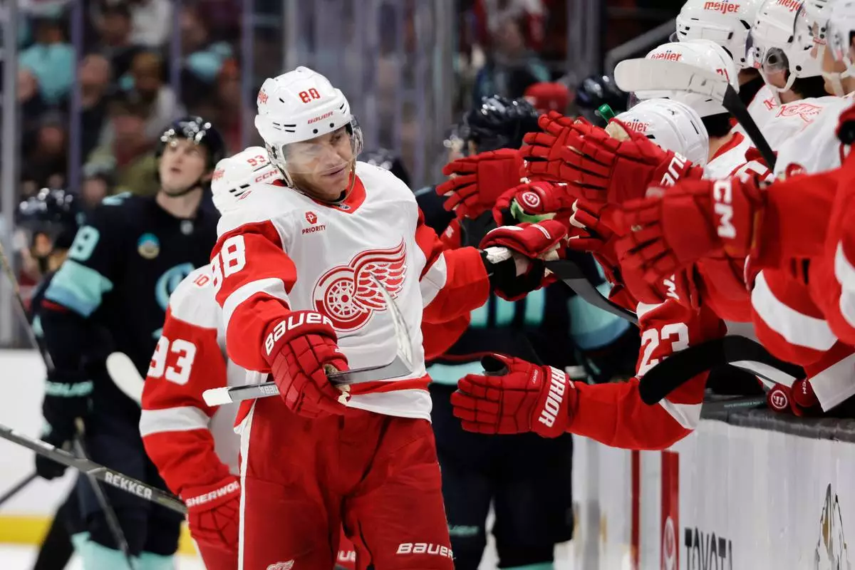 Detroit Red Wings right wing Patrick Kane (88) is congratulated after scoring against the Seattle Kraken during the third period of an NHL hockey game Saturday, Dec. 6, 2025, in Seattle. (AP Photo/John Froschauer)