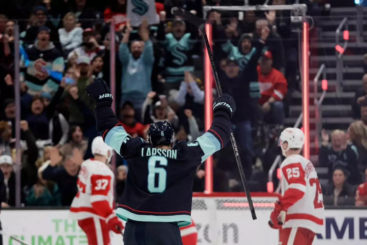 Seattle Kraken defenseman Adam Larsson (6) reacts to a goal by center Chandler Stephenson (9) against the Detroit Red Wings during the second period of an NHL hockey game Saturday, Dec. 6, 2025, in Seattle. (AP Photo/John Froschauer)