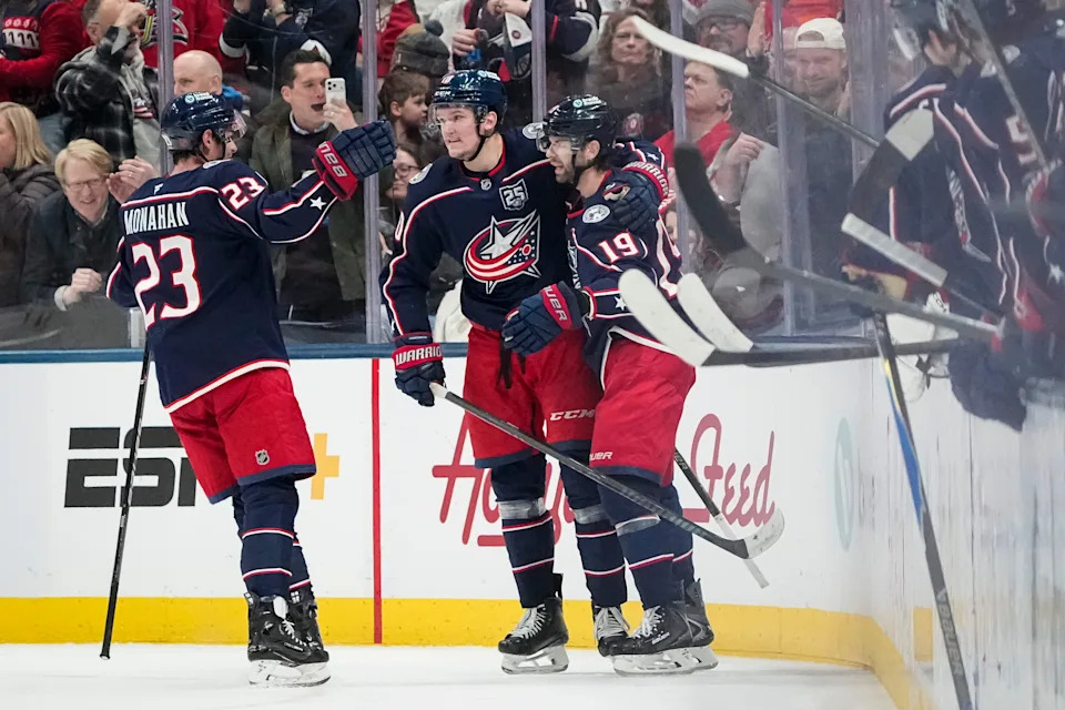 Columbus Blue Jackets left wing Dmitri Voronkov (10) and center Sean Monahan (23) celebrate a goal by center Adam Fantilli during the second period of the NHL hockey game against the Detroit Red Wings at Nationwide Arena in Columbus on Dec. 4, 2025.
